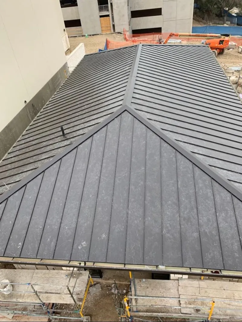 Commercial metal roof construction with crane equipment in Plumas Lake